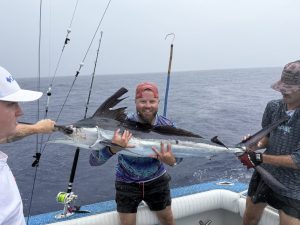 Fishermen Holding Sailfish Boat
